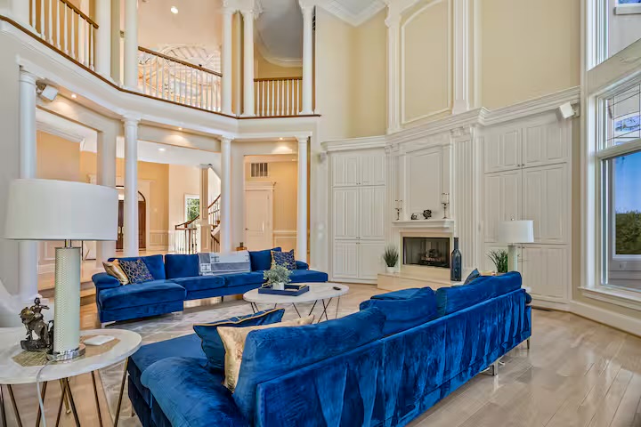 Two-story great room with fireplace and velvet seating